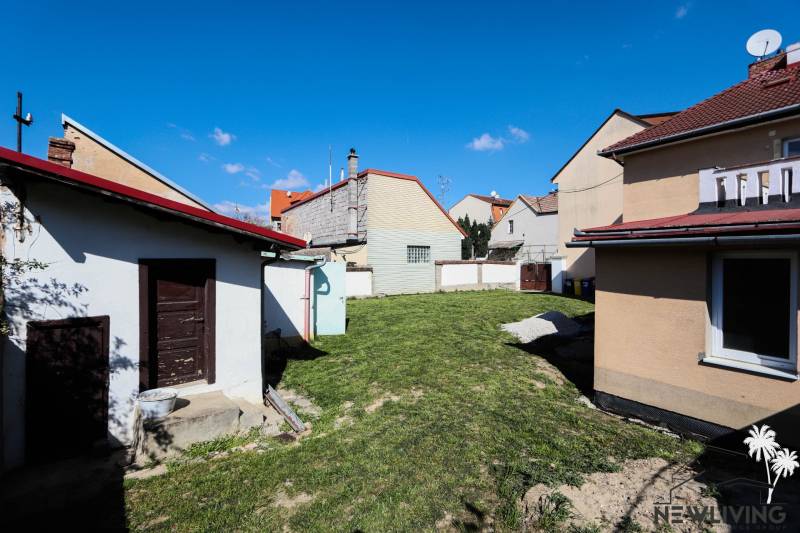 Kert a családi ház mögött a Hviezdoslav utcában, Pöstyénben, tetővel és kerítéssel.