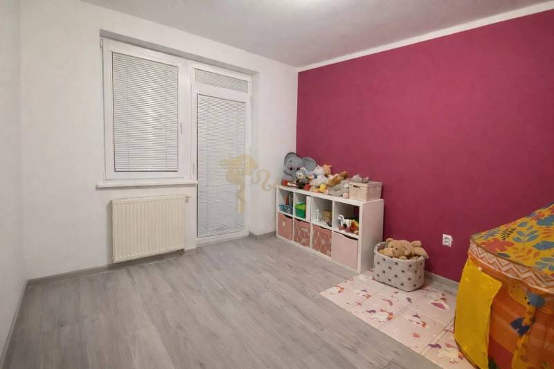 Gyerekszoba egy háromszobás lakásban, fa dekoros padlóval és színes falakkal.