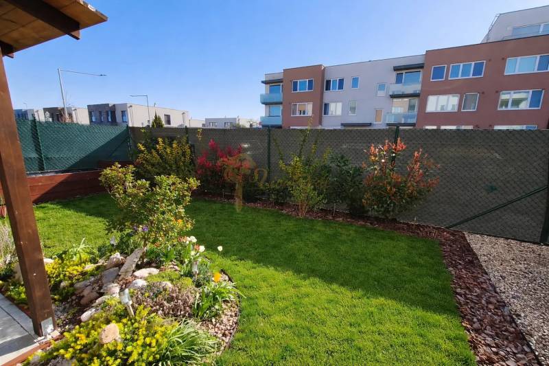 Kert színes virágültetvénnyel a Jaseňová utcában, Miloslavovban, egy 2 szobás lakás mögött.