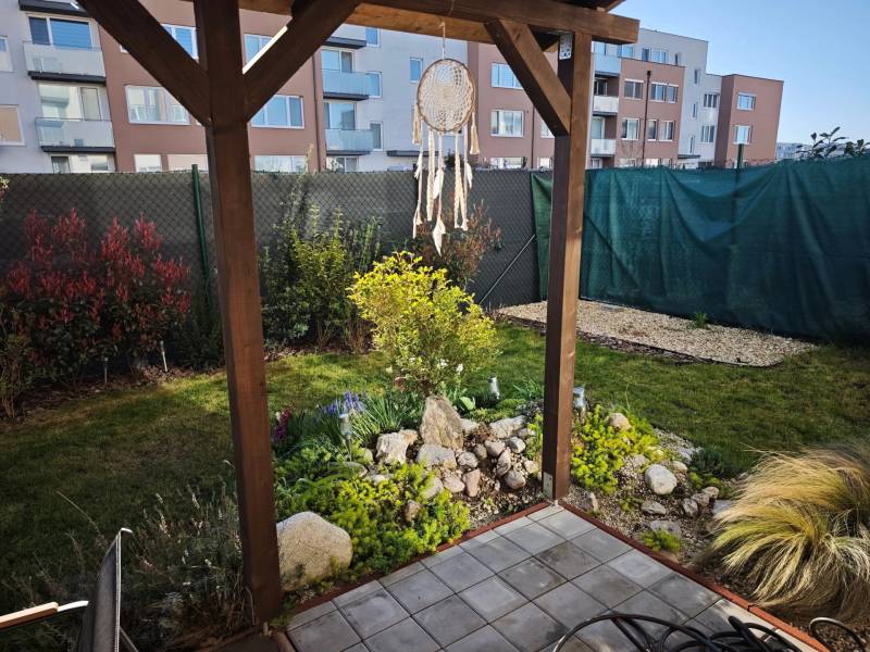 Kert a Jaseňová utcai kétszobás lakásnál Miloslavovban, pergolával és zölddel.