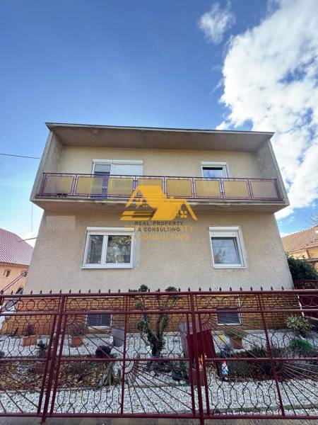 Családi ház Tardoskedden, a Tardoskeddi utcán, erkéllyel és kerítésen kívüli előkerttel.