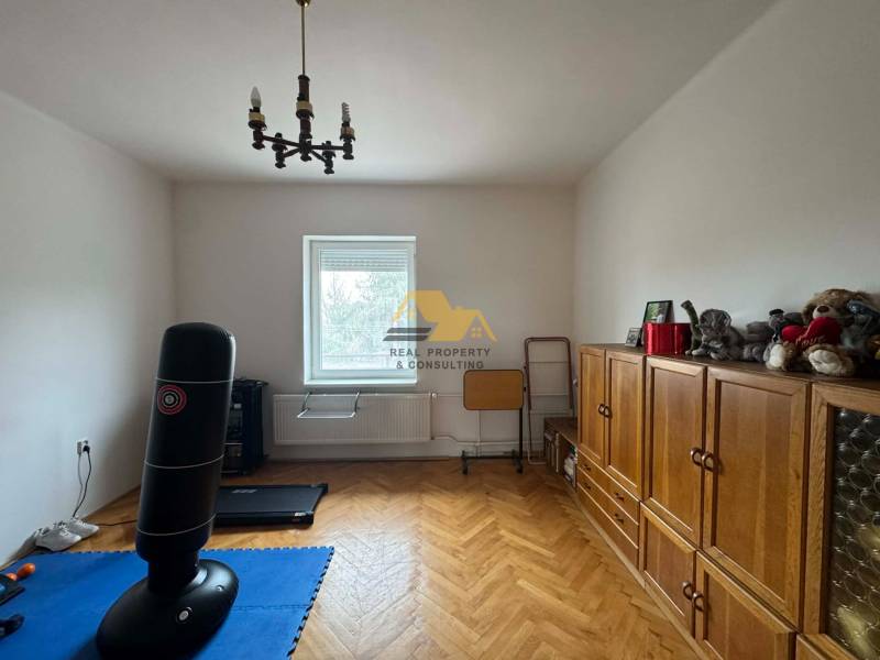Családi ház szoba fa dekor padlóval, bútorokkal és boxzsákkal.