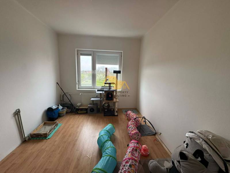 Szoba családi házban, fa dekorációjú padlóval és kilátással a kertre.