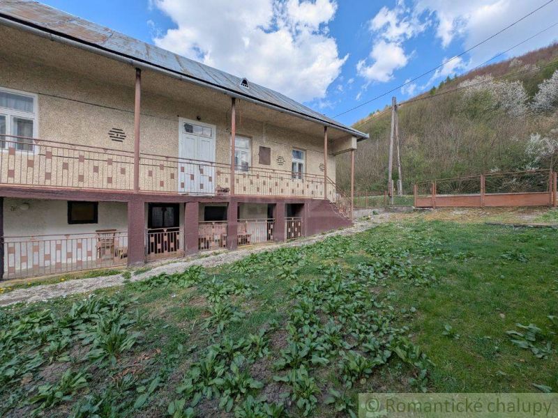 Családi ház Zubnéban nagy verandával, zöld gyepes udvarral és lejtővel.