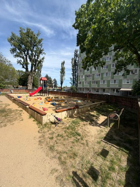 Játszótér Pozsonyban - Petržalkán, homokozóval és csúszdával a lakóház mellett.