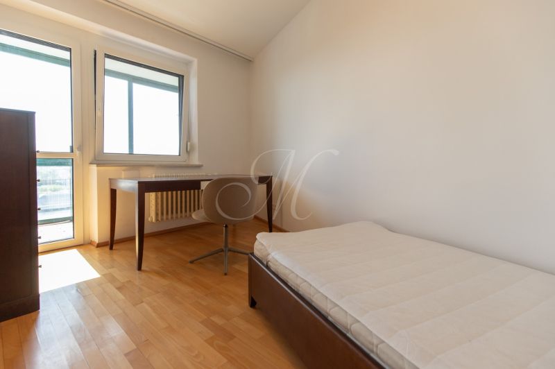 Szoba ággyal, asztallal és fa dekorációjú padlóval egy 4 szobás lakásban.