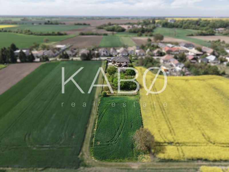 Családi ház a Močenská utcában, Cabaj-Čáporban, zöld és sárga mezők által körülvéve.