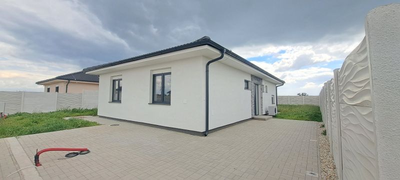 Családi ház Topoľnicán fehér homlokzattal és kövezett udvarral.