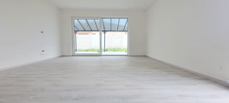 Tágas, világos belső tér fa dekorációjú padlóval egy családi házban.