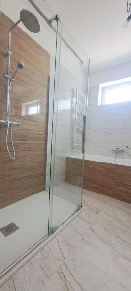 Fürdőszoba modern zuhanyzóval és káddal egy családi házban.