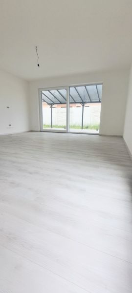 Családi ház belső tere nagy ablakkal és fa dekorációjú padlóval.