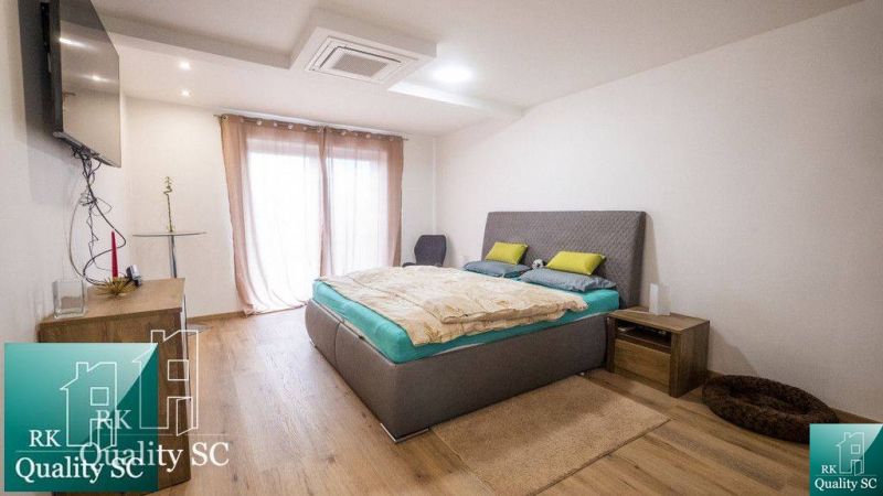 Hálószoba családi házban, fa dekoros padlóval és minimalista berendezéssel.