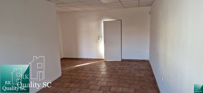 Szoba egy családi házban, csempével és fehér falakkal.