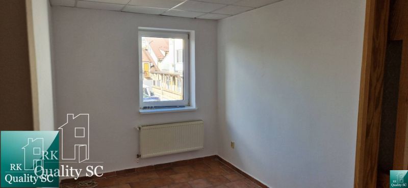 Fehér fal ablakkal, radiátorral és csempével egy családi házban.