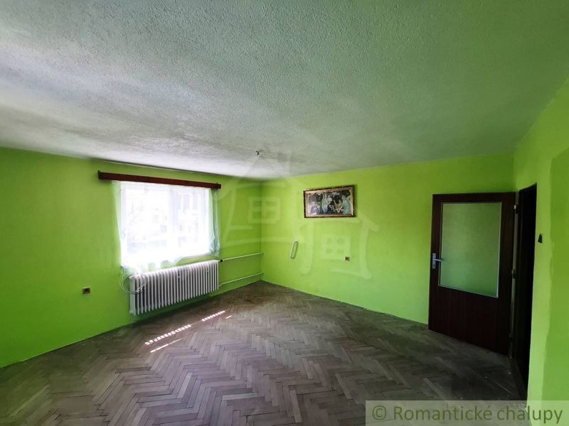 Zöld falak és padló fa dekorációval egy családi házban, napfényes sugarakkal az ablakon keresztül.