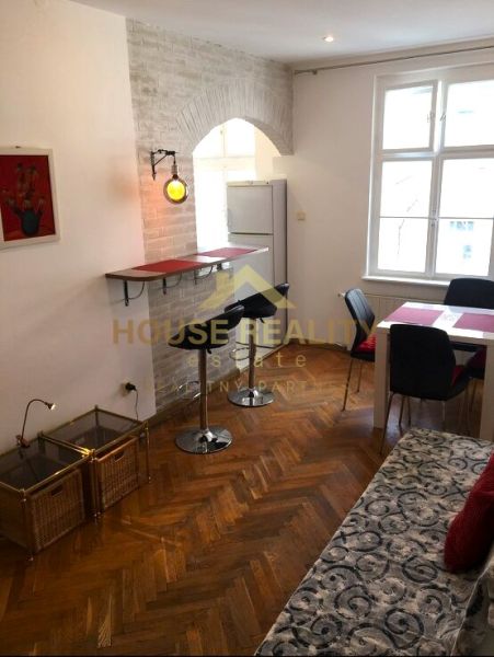 Nappali egy kétszobás lakásban, fa dekorációjú padlóval, bárral és étkezőasztallal.
