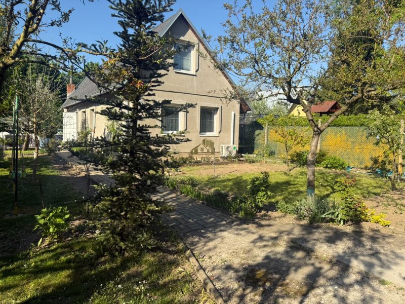 Házikó Sekulén előkerttel, fákkal és rendezett gyepfelülettel a Sekule utcán.