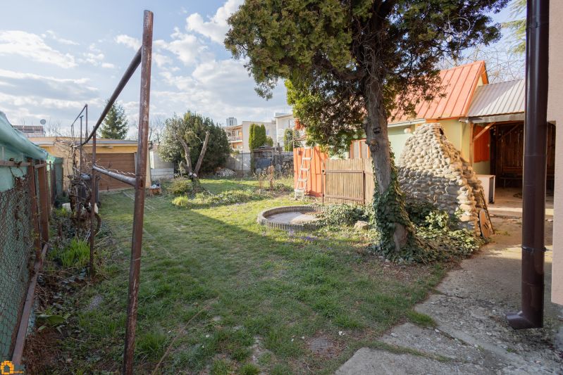 A Piešťany-i Mlynska utcai családi ház kertje gyepes és fákkal van beültetve.