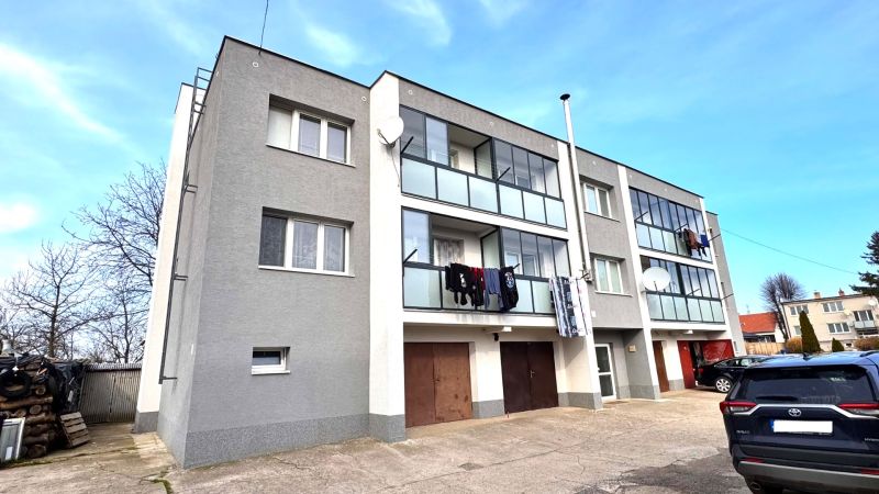 Háromszintes lakóház erkélyekkel és autókkal Hlbokéban.
