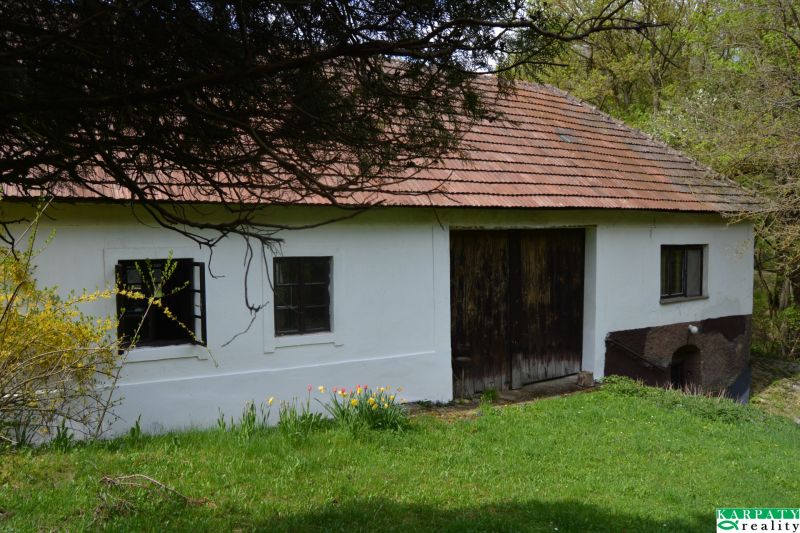 Bukovecben található családi ház ferde tetővel és fa kapukkal.