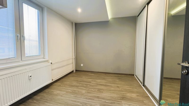 Üres szoba szekrénnyel és fa dekorációjú padlóval egy négy szobás lakásban.