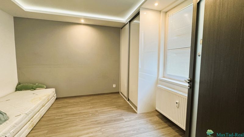 4 szobás lakás belső tere fa dekor padlóval és beépített szekrénnyel.