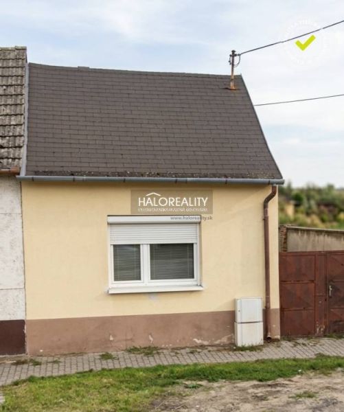 Családi ház Malackán egyszerű homlokzattal és ferde tetővel.