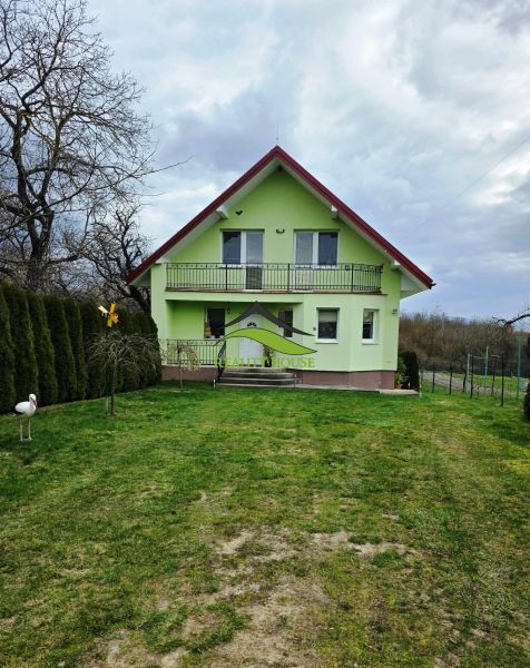 Zöld családi ház Klokočovban verandával és rendezett kerttel.