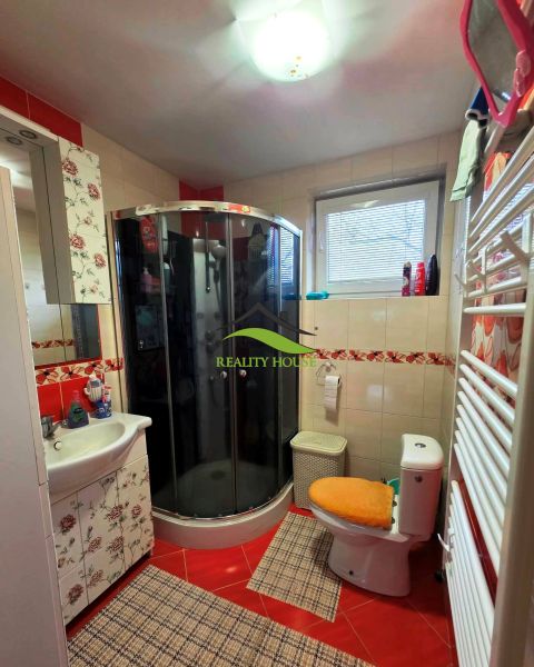 Fürdőszoba családi házban WC-vel, zuhanyzóval és dekoratív csempékkel.