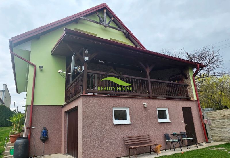 Családi ház Klokočovban fedett terasszal, zölddel és kerti bútorokkal.