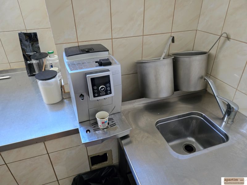 Konyhasarok kávéfőzővel, rozsdamentes acél mosogatóval és szükséges eszközökkel a vendéglátóipari helyiségekben.