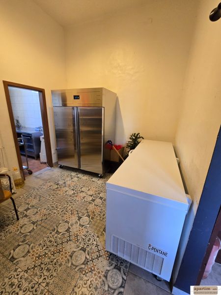 Hűtőhelyiség csempével a vendéglátóipari területeken, amely tartalmaz egy fémszekrényt és egy fagyasztót.