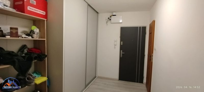 Folyosó egy kétszobás lakásban beépített szekrénnyel és polcokkal tárolásra.