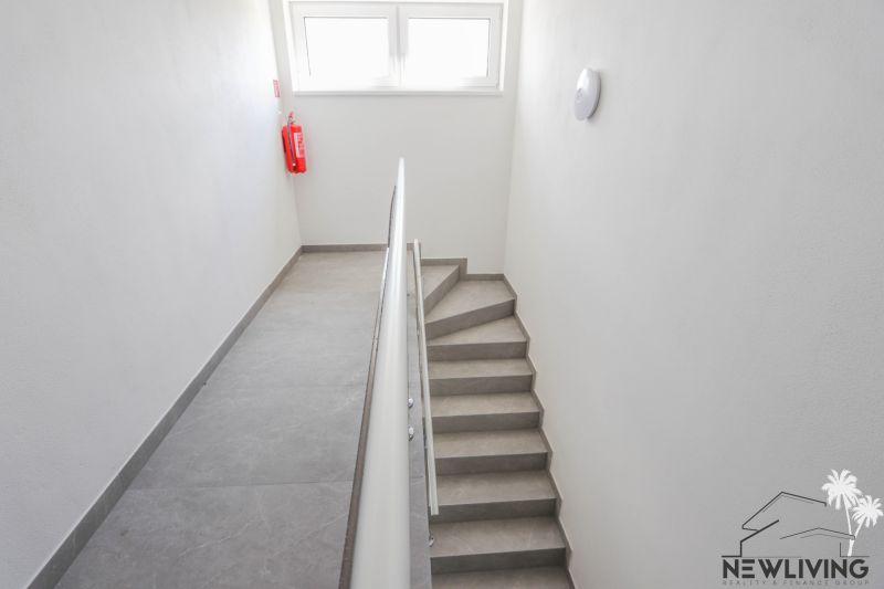 Lépcső egyszerű korláttal és ablakokkal egy 4 szobás lakásban.