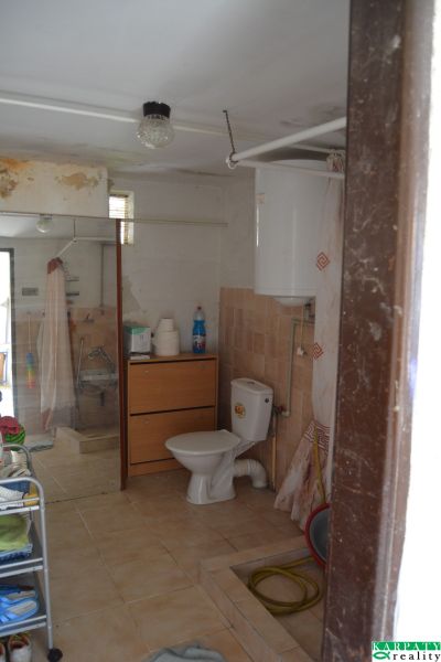 Fürdőszoba családi házban csempével, zuhanyzóval és WC-vel.