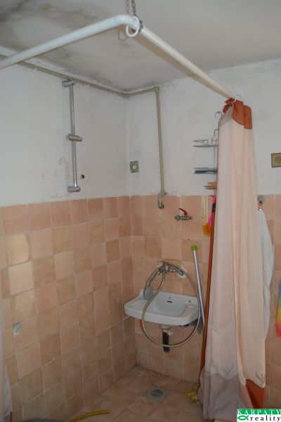 Fürdőszoba csempével és függönnyel egy családi házban, egyszerű mosdókagyló.