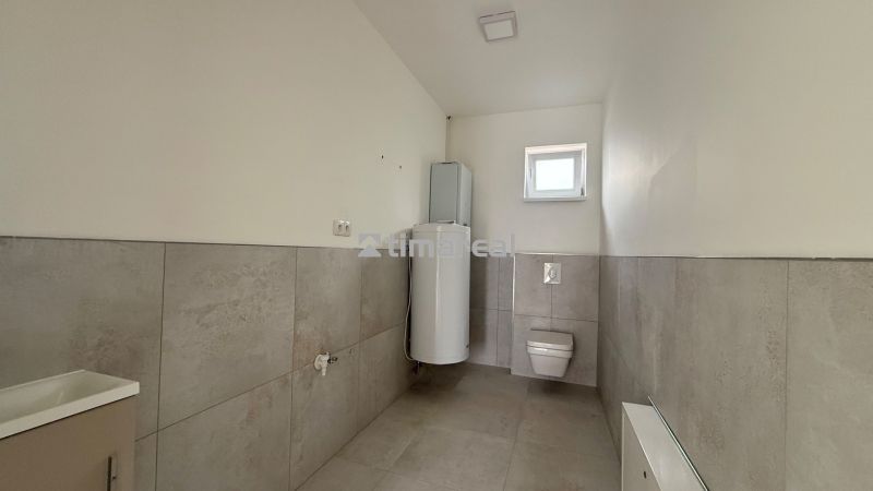 Családi ház fürdőszobája WC-vel és vízmelegítővel.