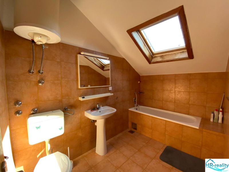 Fürdőszoba a nyaraló apartmanban káddal és tetőablakkal.
