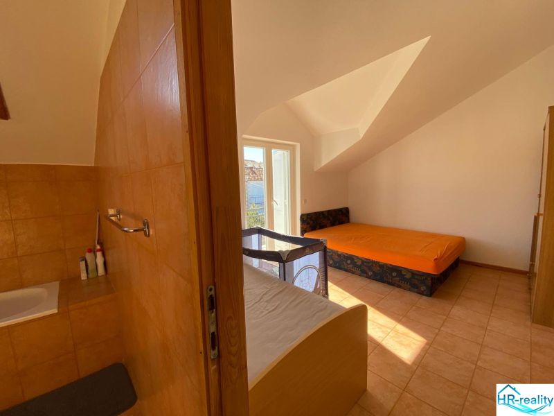 Nyaraló apartman belső tere kanapéval, ággyal és gyerekággyal.