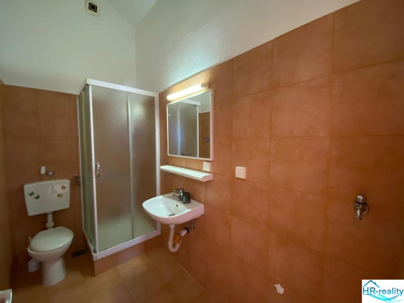 Fürdőszoba a nyaraló apartmanban mosdóval és zuhanyzóval.