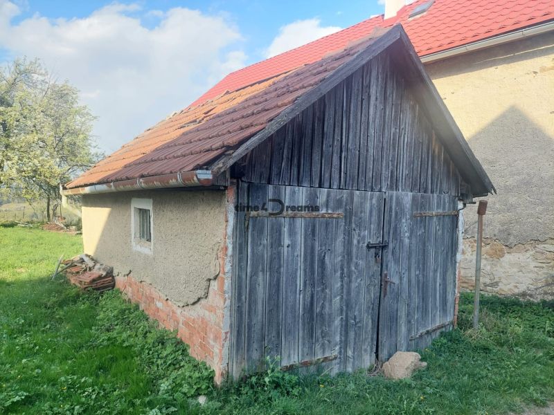 Régi fa garázs egy lakótelek Budinán, zölddel és fákkal körülvéve.