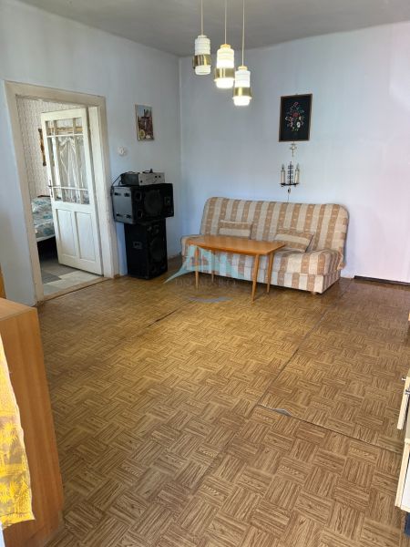 Nappali egy családi házban kanapéval és fa dekorációjú padlóval.