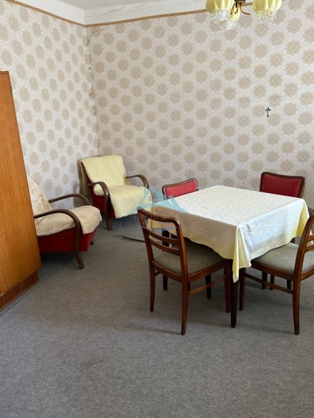 Szoba családi házban retro bútorokkal, tapétákkal és szőnyegpadlóval.