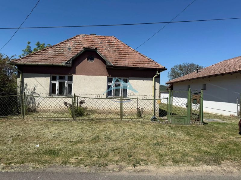 A Honti családi háznak ferde teteje van és fém kerítéssel van körbekerítve.