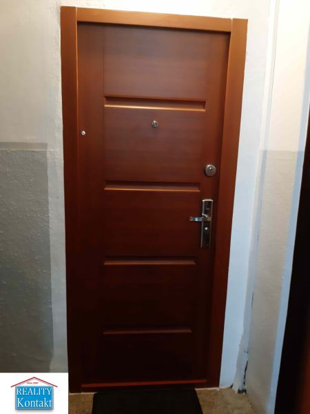 Barna bejárati ajtó egy 2 szobás lakásban biztonsági vasalattal.