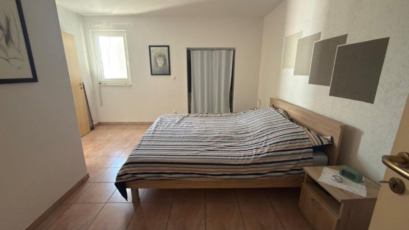 Hálószoba családi házban ággyal, kerámia padlóval és minimalista dekorációval.