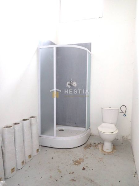 A képen egy zuhanyzó és egy WC látható a gyártóhelyiségekben.