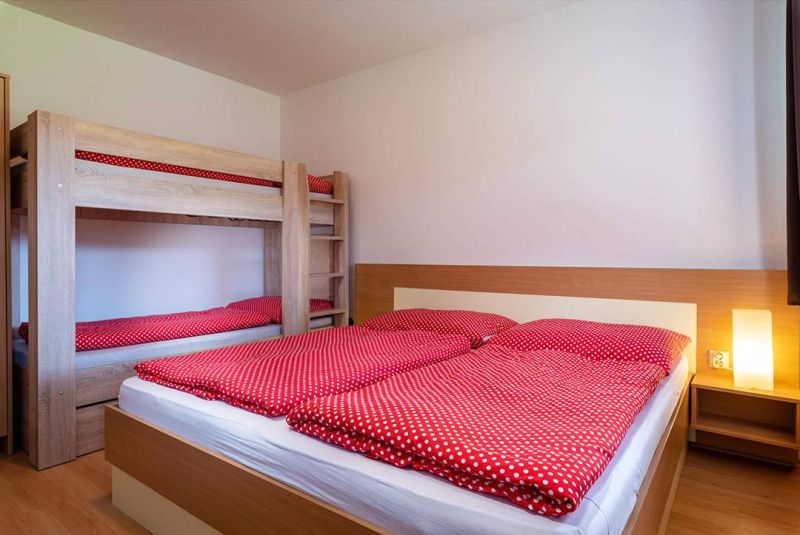 A rekreációs apartman kényelmes hálószobát kínál emeletes ággyal és fa dekorációjú padlóval.