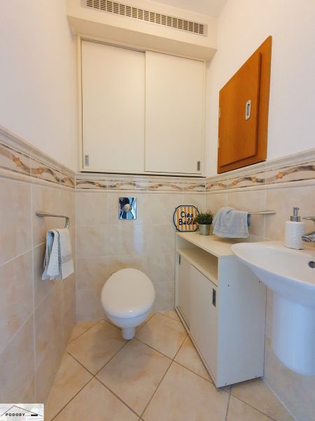 Fürdőszoba a háromszobás lakásban WC-vel, mosdóval és szekrénnyel.
