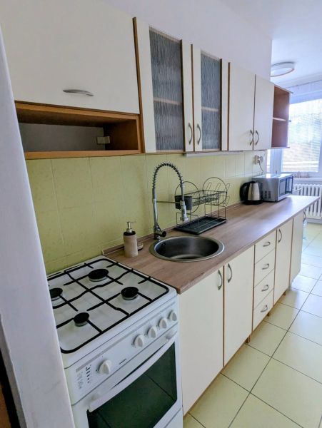 Konyha egy kétszobás lakásban tűzhellyel, mosogatóval és konyhabútorral.